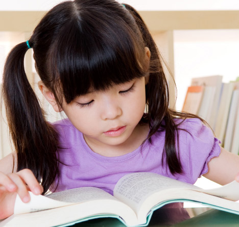 School child reading a book